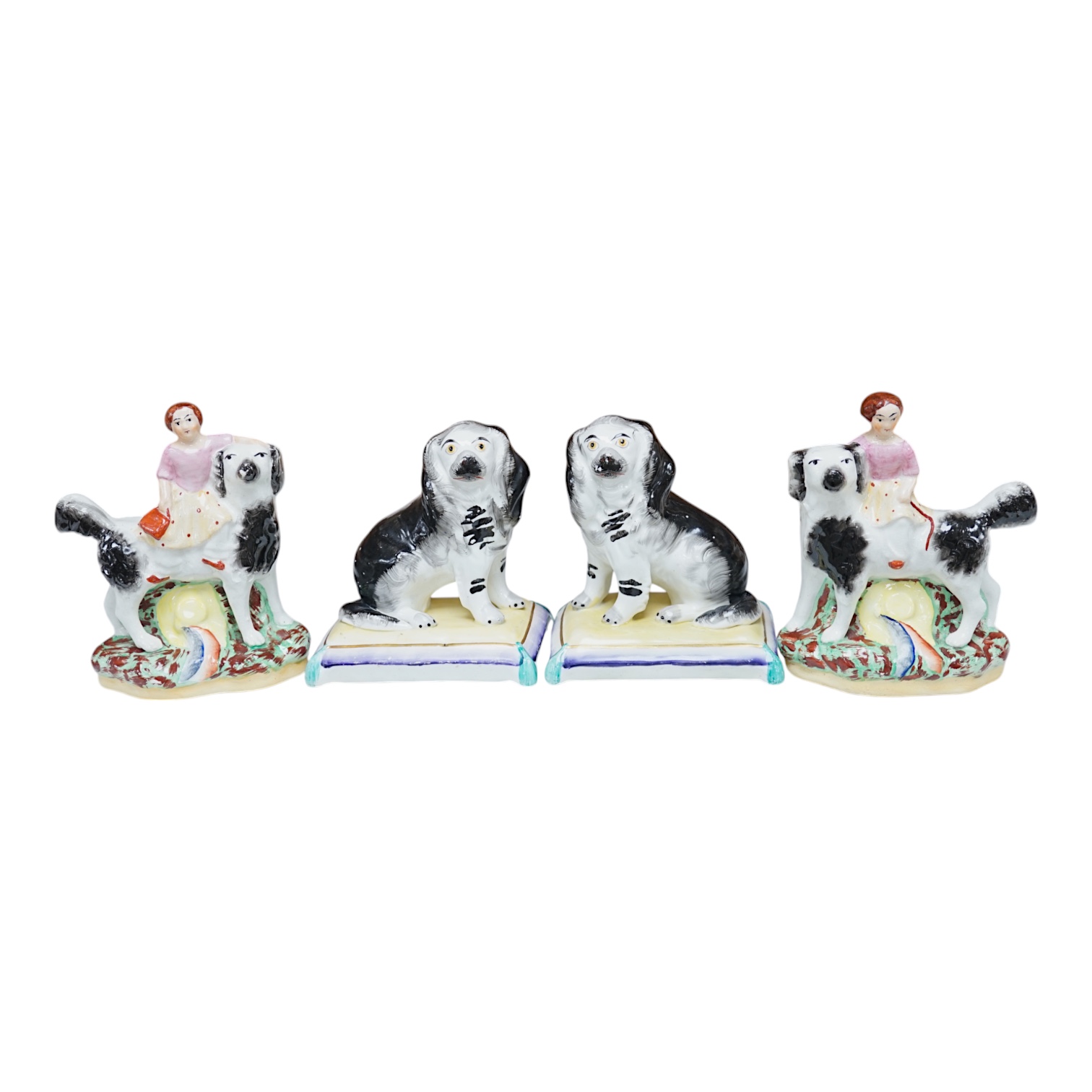 A pair of mid 19th century Staffordshire spaniels seated on cushions and a pair of similar groups of children riding spaniels (4), tallest 14cm. Condition - some minor flaking to paint, otherwise good